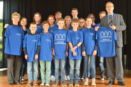 Der Vorsitzende des Förderkreises Nils Kambach (r.) überreicht die Shirts an die Schulleiterin Frau Woltmann (l.) und laufbegeisterte Schülerinnen und Schüler. Der Vorsitzende des Förderkreises Nils Kambach (r.) überreicht die Shirts an die Schulleiterin Frau Woltmann (l.) und laufbegeisterte Schülerinnen und Schüler.